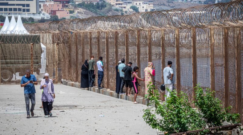 Familiares de jóvenes marroquíes que han cruzado a Ceuta sin haber vuelto aún esperar su retorno este sábado en la valla de la frontera de Castillejos.