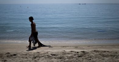 Un joven marroquí llegado a Ceuta recientemente recoge ropa del fondo del mar en la playa del Taraja, este viernes.